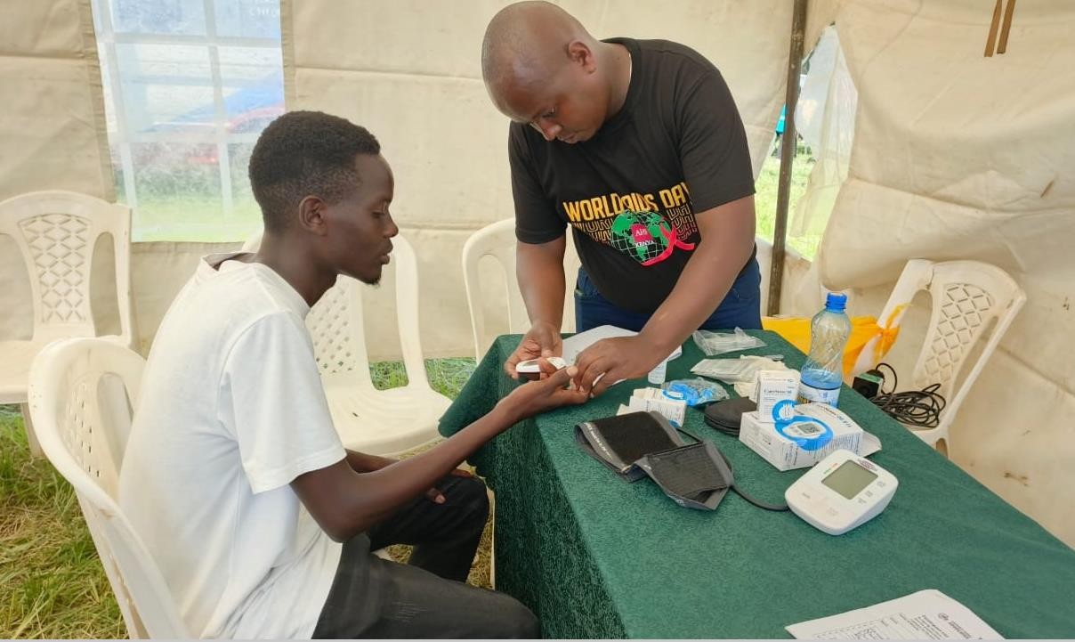 CCA staff taking a blood pressure reading at a community health outreach.